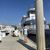 Passengers are boarding a vintage-style paddlewheel boat docked at a pier under a clear blue sky.