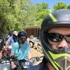 A group of people wearing helmets are preparing for an ATV adventure outdoors.