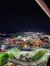 The image captures a bustling amusement park with go-kart tracks and colorful lighting at nighttime, viewed from an elevated perspective.