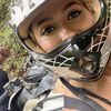 Two individuals wearing helmets are posing for a selfie while enjoying an outdoor adventure with an ATV.