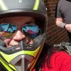 Three people wearing helmets are posing for a selfie with a clear blue sky in the background, seemingly preparing for or returning from a ride on recreational vehicles.