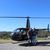 Two people are standing in front of a helicopter with 