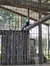 A black panther is lounging on a log inside a fenced enclosure.