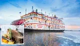 The image shows the Georgia Queen, a large paddlewheel riverboat, beautifully illuminated and adorned with festive lighting, gliding along the water at twilight.