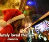 A child in a Santa hat looks longingly out of a window at night towards a brightly lit Ferris wheel with the caption Absolutely loved this - Jennifer