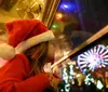 A child in a Santa hat looks longingly out of a window at night towards a brightly lit Ferris wheel with the caption Absolutely loved this - Jennifer