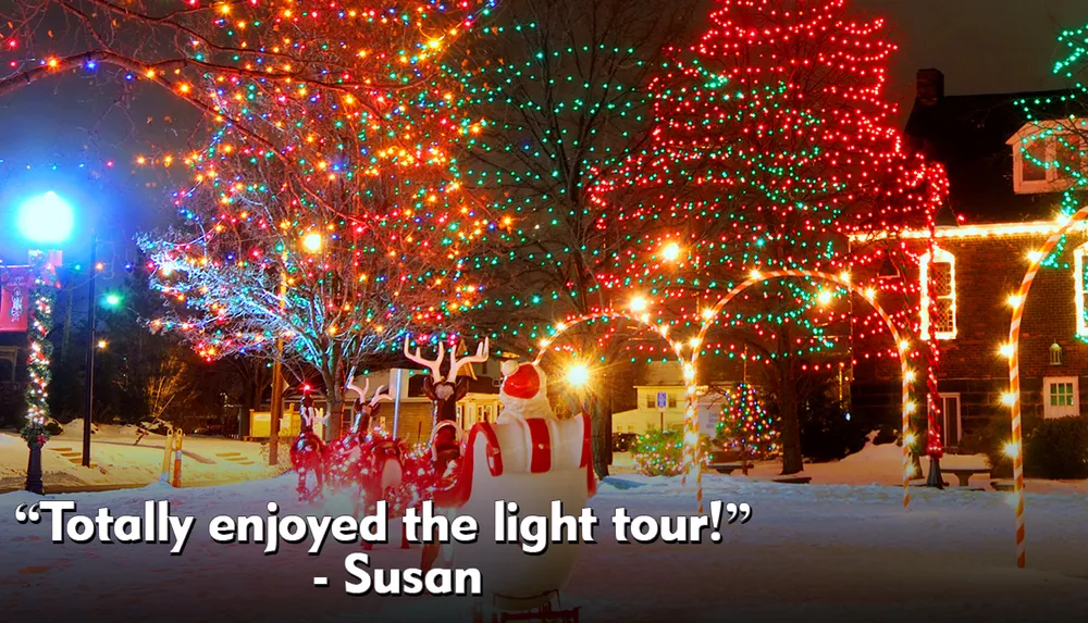 A festive outdoor scene at night featuring trees adorned with colorful Christmas lights and a Santa Claus figure in the foreground enhanced by a snow-covered ground and a testimonial text overlay attributing enjoyment of the light tour to Susan