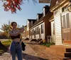 A person is taking a selfie on a sunny street lined with historical buildings