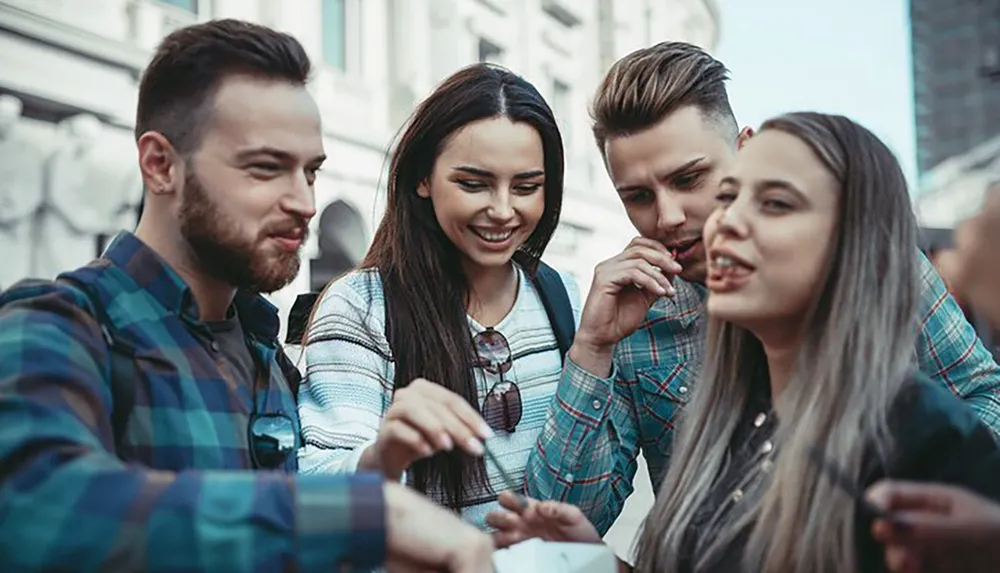 Four friends are sharing a meal and enjoying each others company on a city street