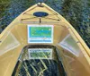 A yellow kayak with a transparent bottom and a map attached to the front is on clear water revealing aquatic plants below