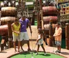 A family of four is enjoying a game of miniature golf with a pirate ship backdrop