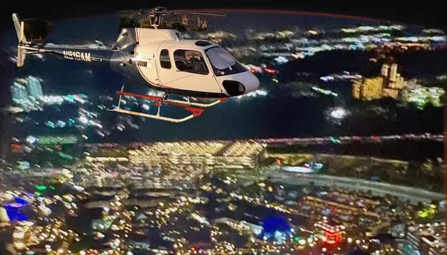 A helicopter is flying over a brightly lit cityscape at night.