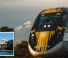 A high-speed train with distinctive yellow and black markings travels through a natural landscape during what appears to be the golden hour of sunlight