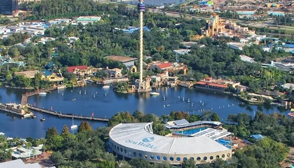 An aerial view shows part of a theme park with water attractions distinctive buildings and lush greenery prominently featuring a structure with the SeaWorld logo