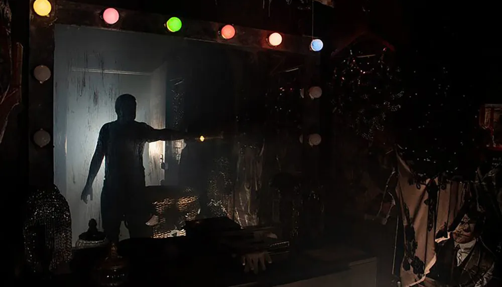 A silhouette of a person is seen through a foggy glass door decorated with colorful lights in a dimly lit room creating a mysterious atmosphere