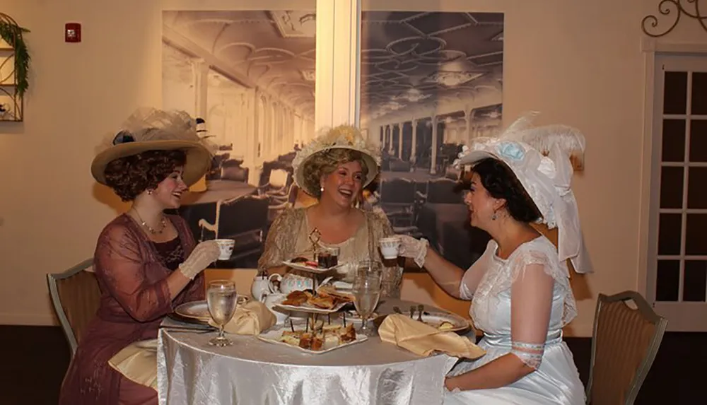 Three women dressed in vintage clothing enjoy a lively tea party