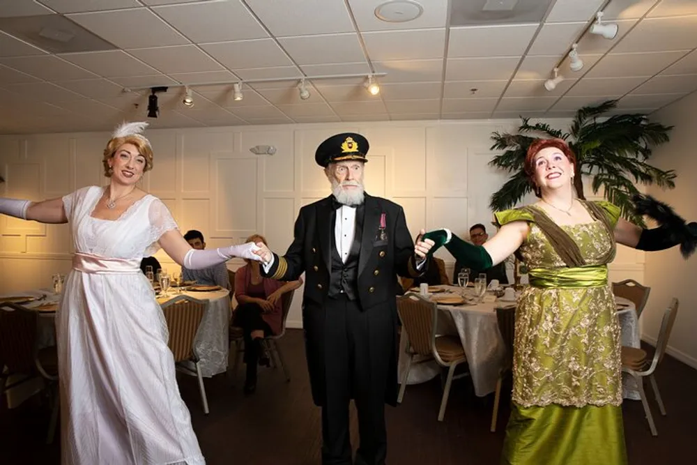 Three individuals are dressed in vintage clothing reminiscent of the early 20th century and appear to be engaged in a theatrical or themed event inside a dining room