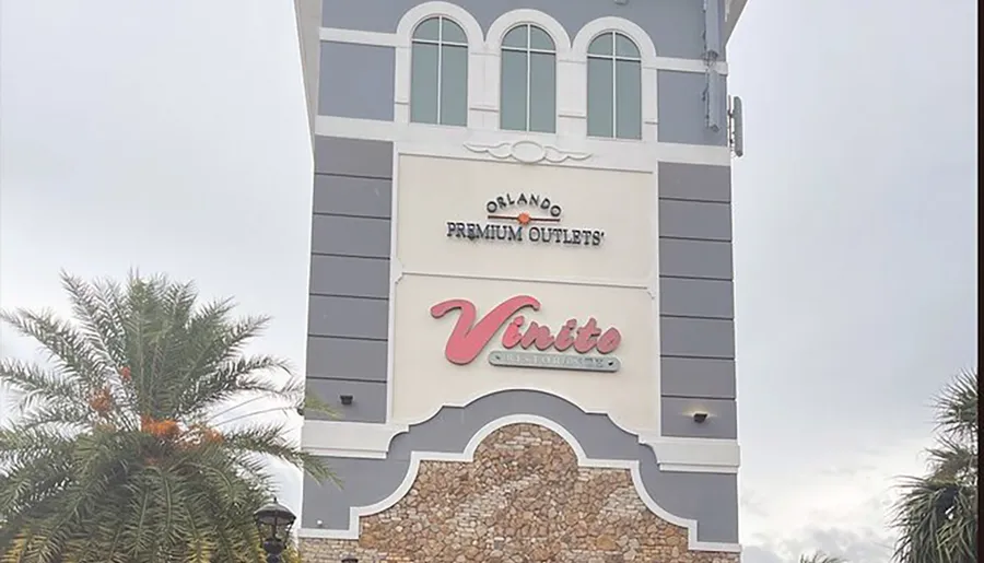 The image shows the exterior facade of a building with signs for Orlando Premium Outlets and Vinito Ristorante, suggesting it's a location that houses a dining establishment within a shopping outlet complex.