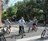 A group of men are engaged in a conversation on a street with colorful buildings two of whom are on bicycles