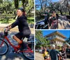 Two people are riding bicycles through a scenic park with large trees draped in Spanish moss