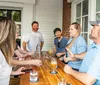 A group of people are enjoying a friendly conversation at an outdoor bar setting with drinks on the table