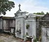 The image shows a row of above-ground tombs and mausoleums with varying designs characteristic of a historic cemetery