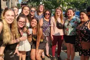 A group of people smiling and posing together for a photo on a sunny day.