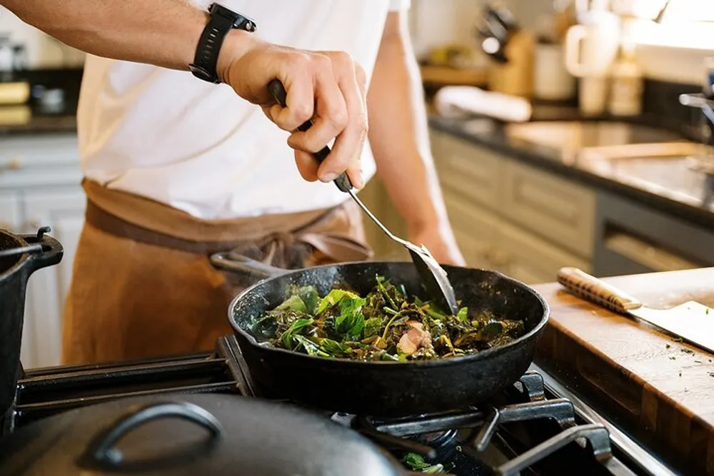 A person is sauting vegetables in a pan on a stove