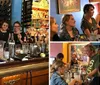 A group of people is posing with smiles behind a bar counter cluttered with cocktail-making equipment and glasses