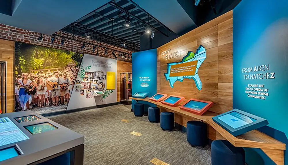 The image shows a modern museum exhibit with interactive displays colorful informational panels and a map highlighting Southern Jewish communities