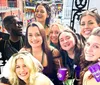 A group of people are enjoying themselves on a balcony with drinks beads and smiles possibly during a festive event