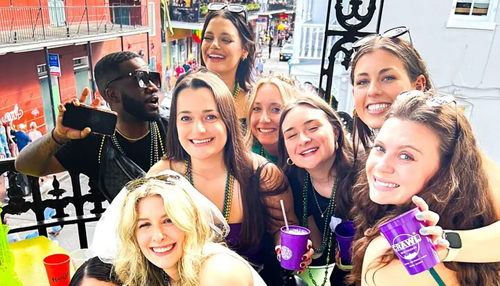 A group of people are enjoying themselves on a balcony with drinks beads and smiles possibly during a festive event