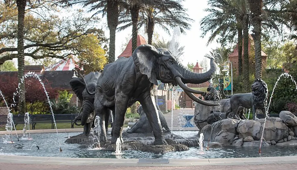 The image captures a dynamic fountain display featuring statues of elephants and lions surrounded by water jets set in a serene landscape with palm trees and a clear sky