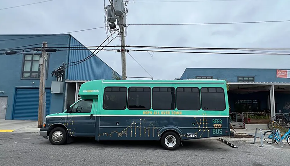 A colorful bus labeled Beer Bus is parked on a street with a blue building in the background