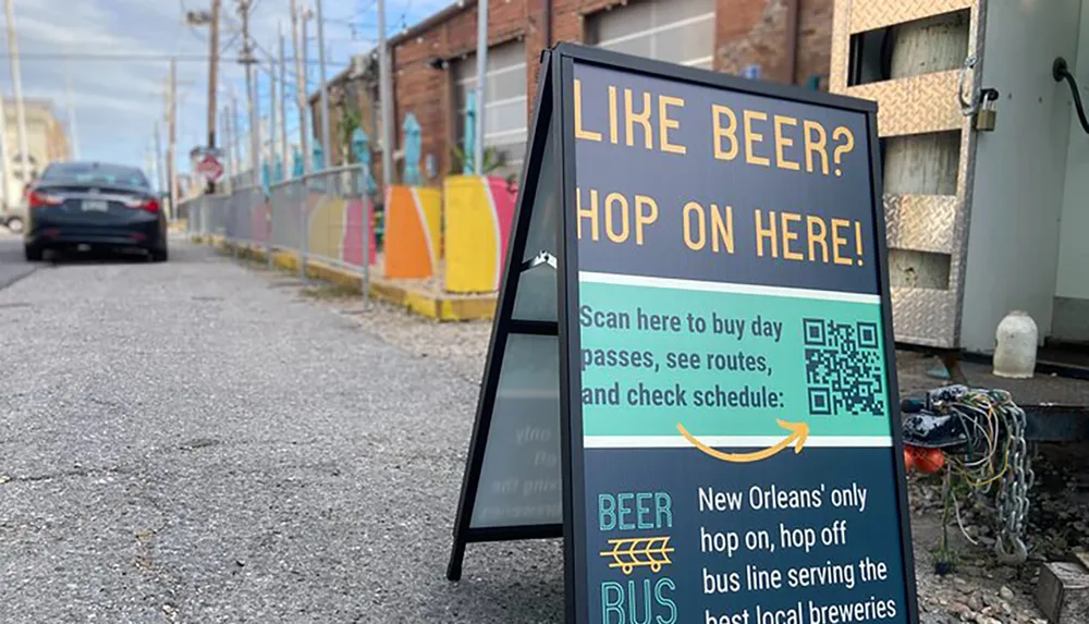 The image shows a sidewalk sign advertising a beer-themed bus tour inviting people to scan a QR code for tickets and information