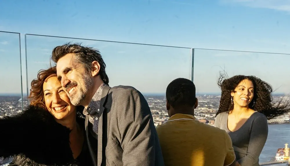 A group of people enjoys a sunny day on a rooftop with a panoramic city view