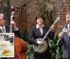 A trio of musicians play instruments in an outdoor setting with an inset of a table featuring a plate of food and a drink