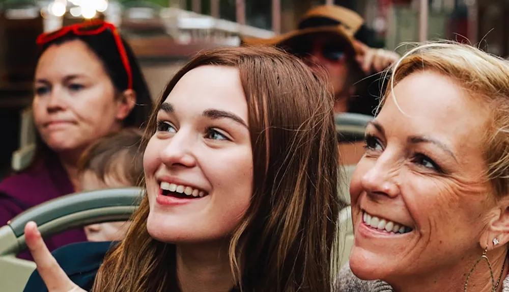 Two women are smiling and posing for a photo on a bus