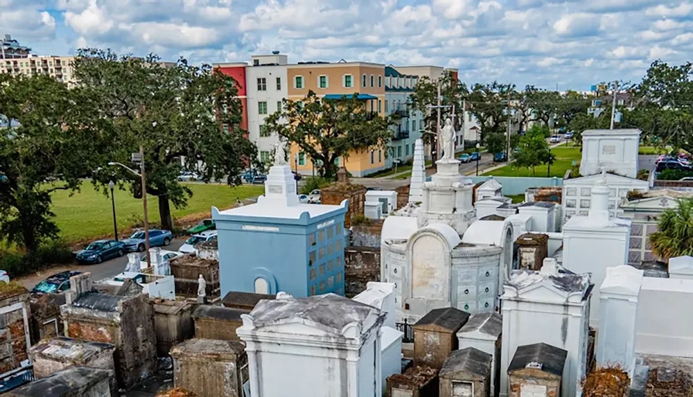 The image shows an aerial view of a cemetery with ornate above-ground tombs and colorful buildings in the background