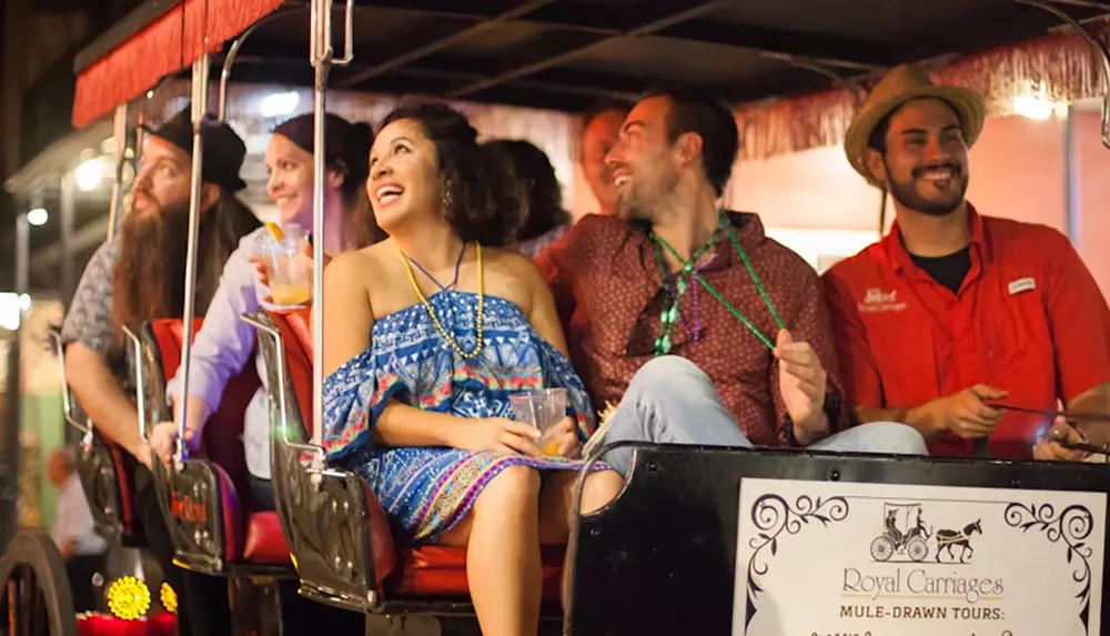 A group of people joyfully riding in a mule-drawn carriage at night