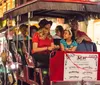 A group of people are enjoying a horse-drawn carriage ride on a lively city street at night