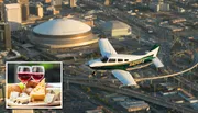 The image features a small airplane flying over a cityscape at sunset, with an inset picture showing glasses of red wine paired with a selection of cheeses and bread.