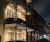 A group of people is attentively listening to a guide during an evening walking tour on a city street