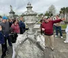 A group of people are listening to a guide during a tour in a cemetery