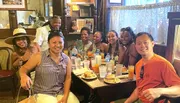 A group of cheerful people is enjoying a meal together at a restaurant.