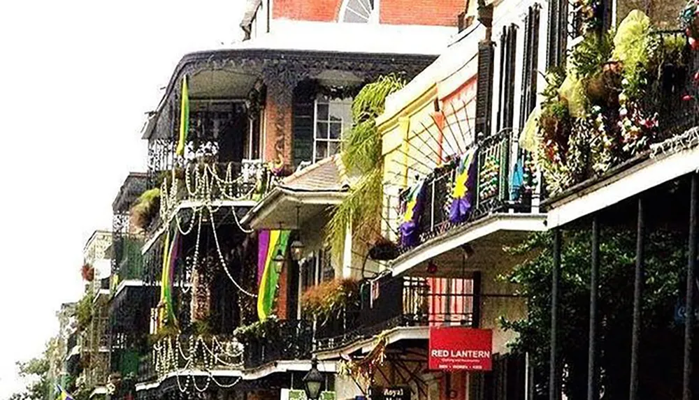 This image features balconies adorned with Mardi Gras decorations and bead necklaces hinting at the festive atmosphere in a place that could be New Orleans French Quarter