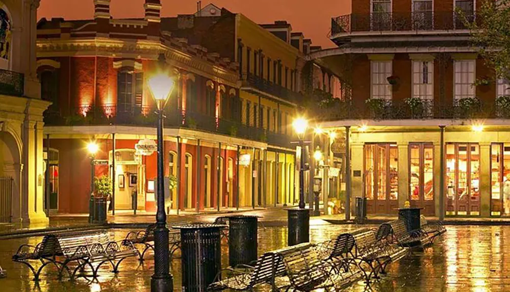 A wet evening scene showcasing the reflective charm of a quiet lamp-lit street with historic architecture typical of New Orleans French Quarter