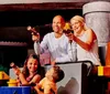 A family is posing with a life-sized Lego pirate figure all smiling cheerfully in a colorful playful setting