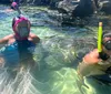 A person is giving a thumbs-up while snorkeling underwater