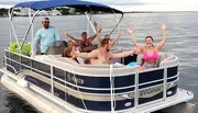 A group of people express joy while cruising on a pontoon boat.